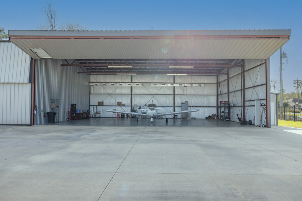 An aircraft inside an actual CXO Hangar with the hangar door open
